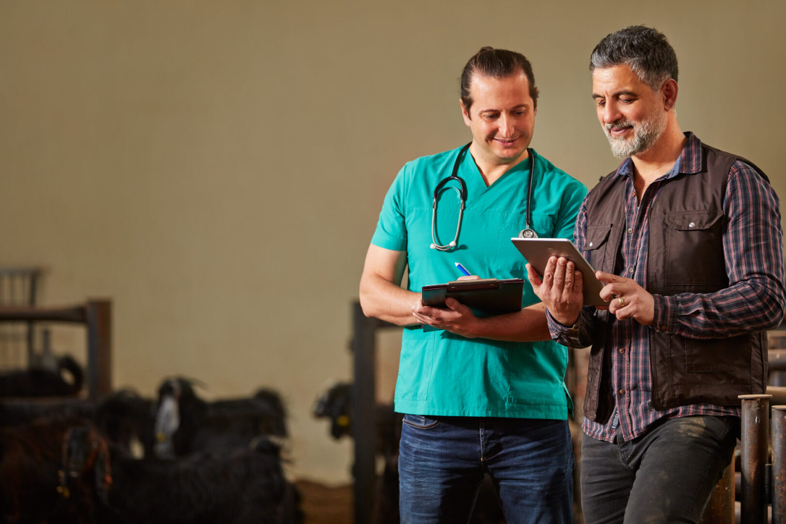 Two men standing next to each other in a barn