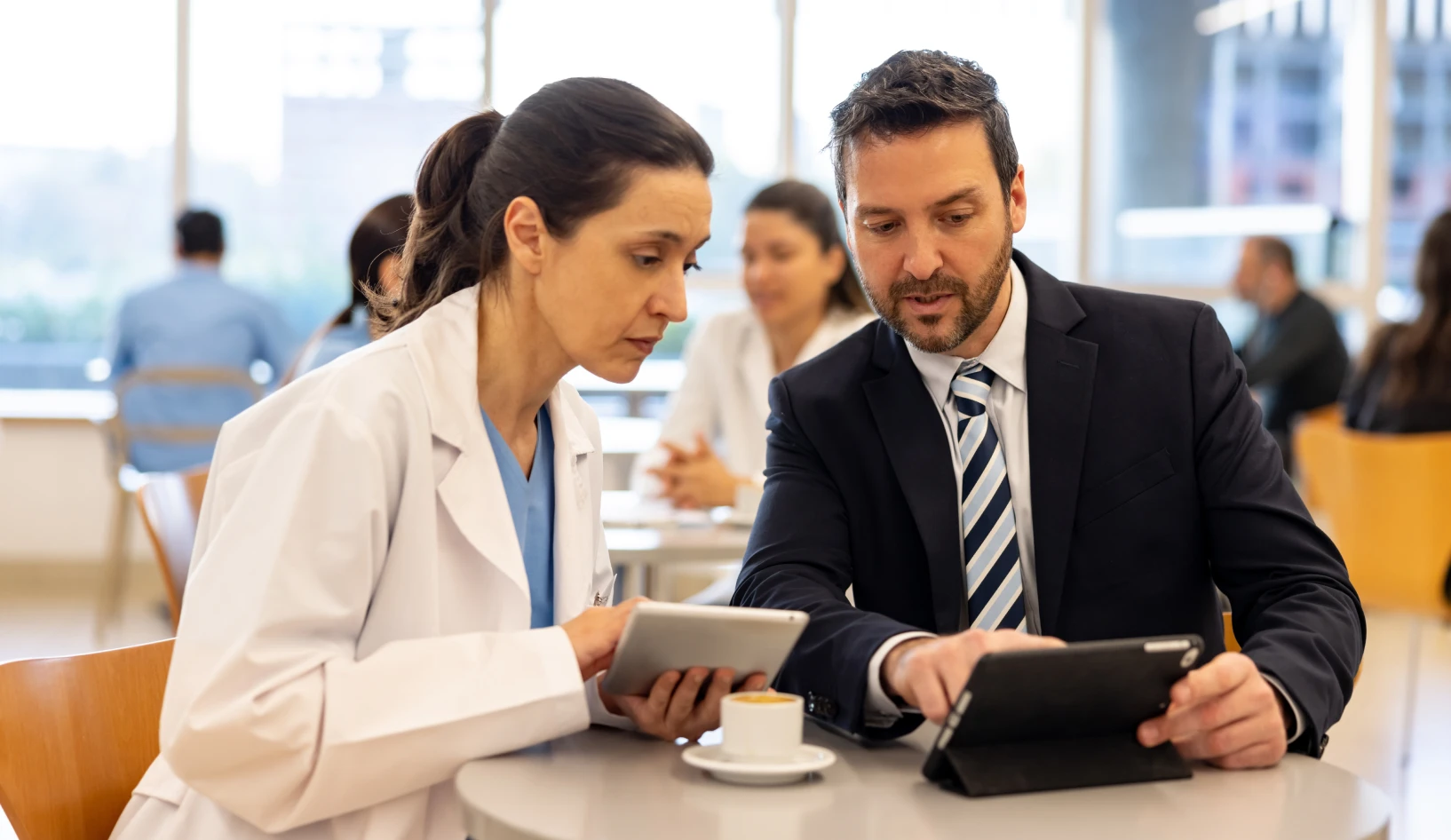 Doctor and businessman collaborating with tablets