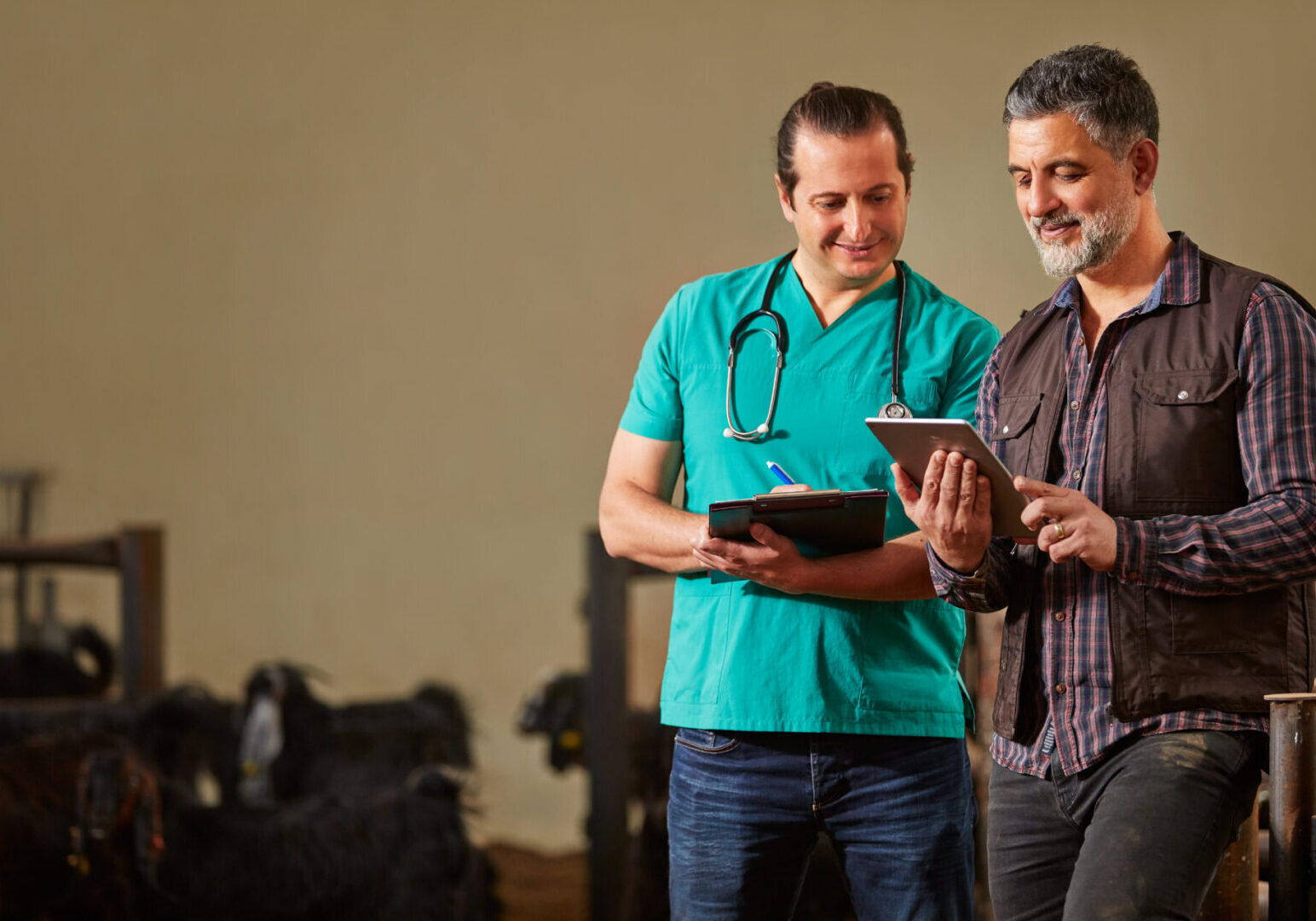 Two men standing next to each other in a barn